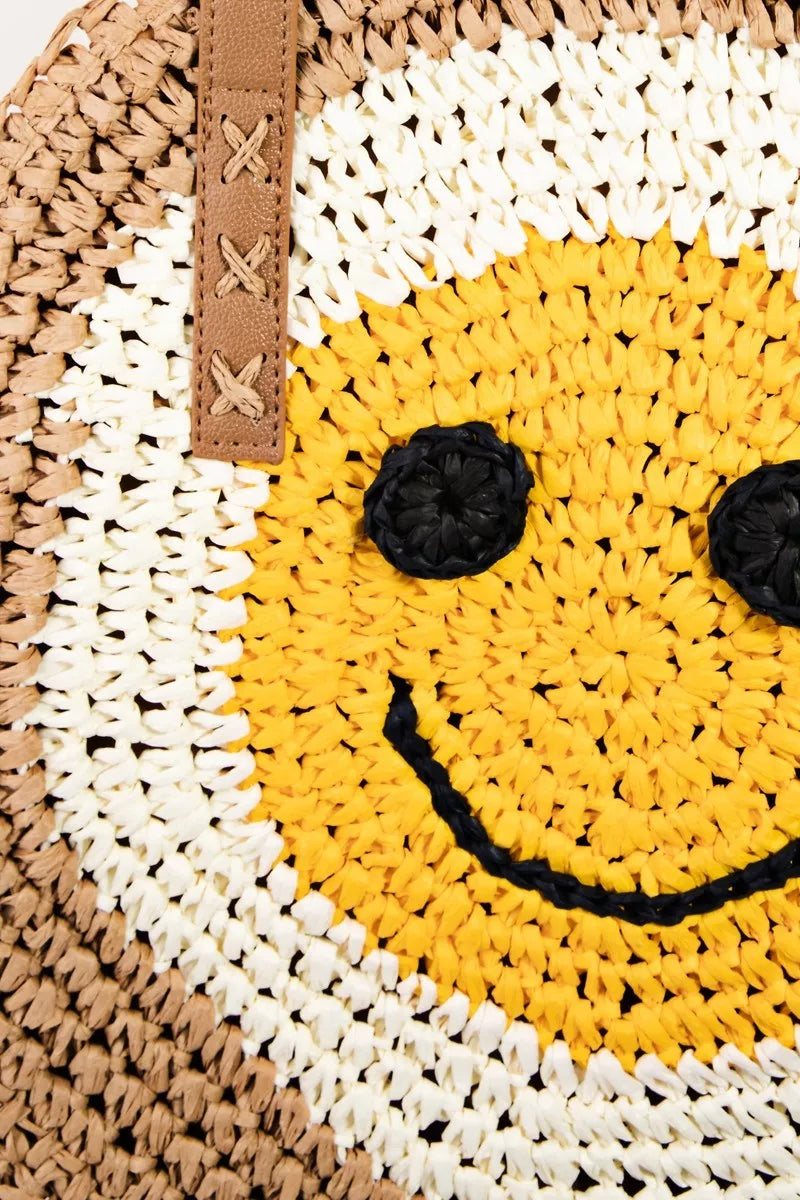 Woven bag with a smiley face design featuring yellow, black, and white colors.