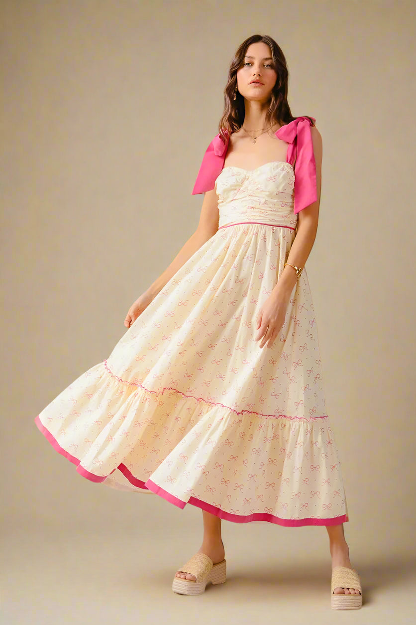 Woman wearing a white dress with pink accents on a plain background