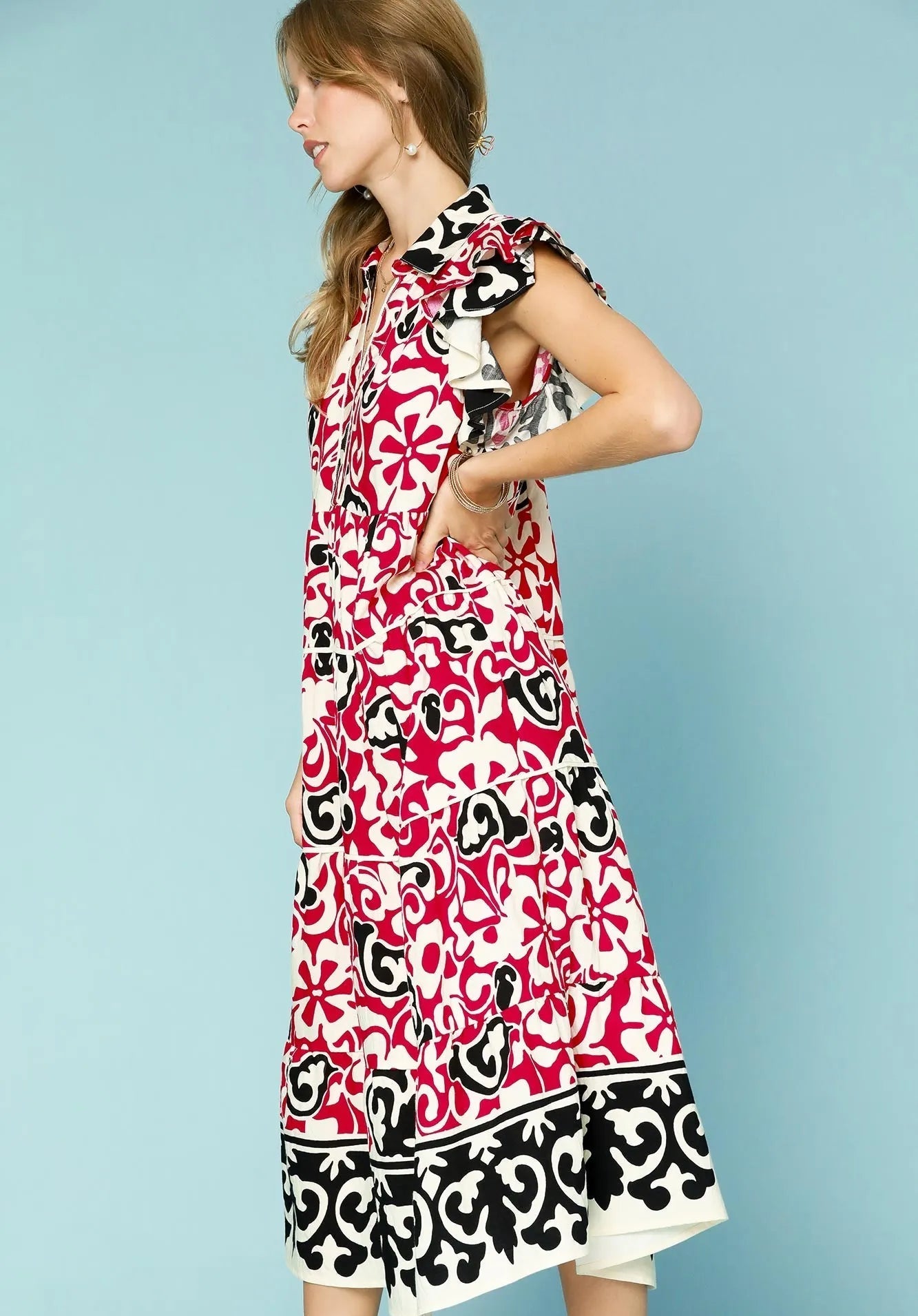 Woman wearing a red and black patterned dress against a light blue background