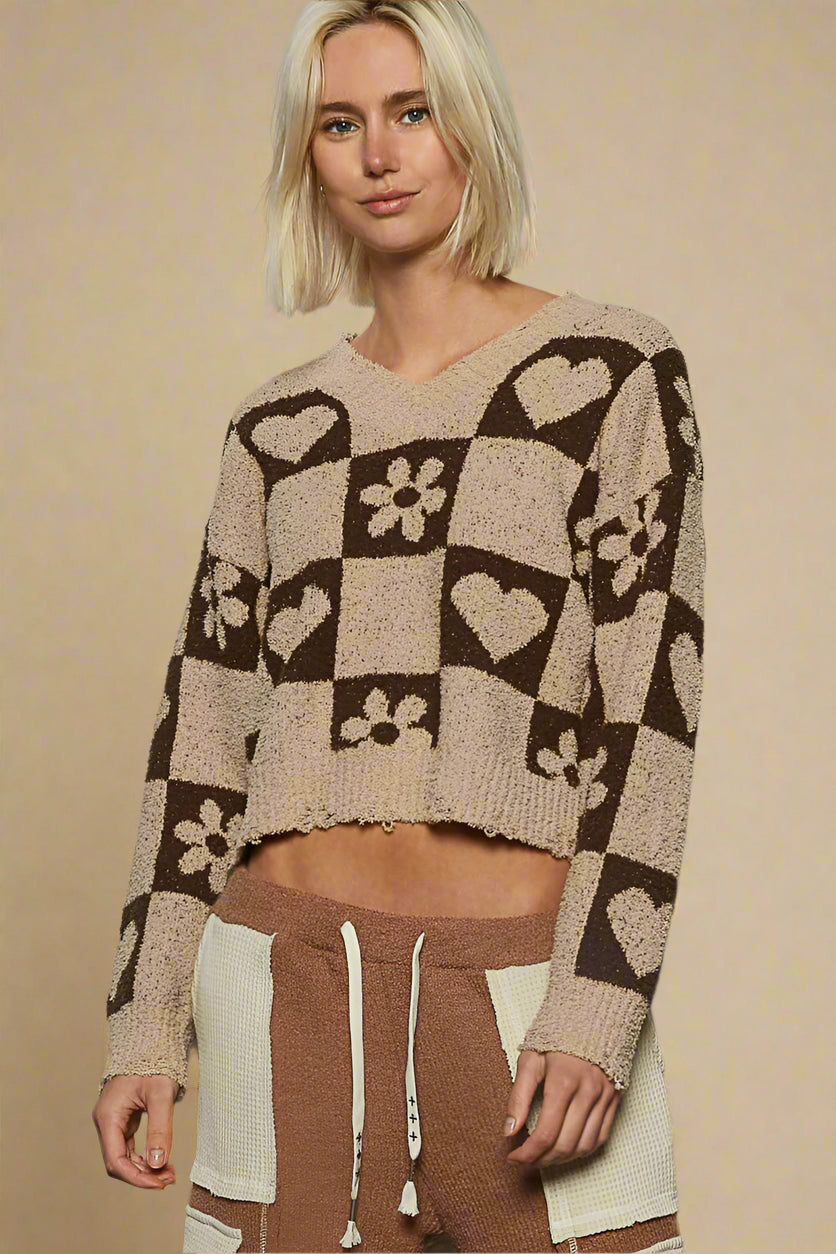 Woman wearing a patterned sweater and pants against a beige background