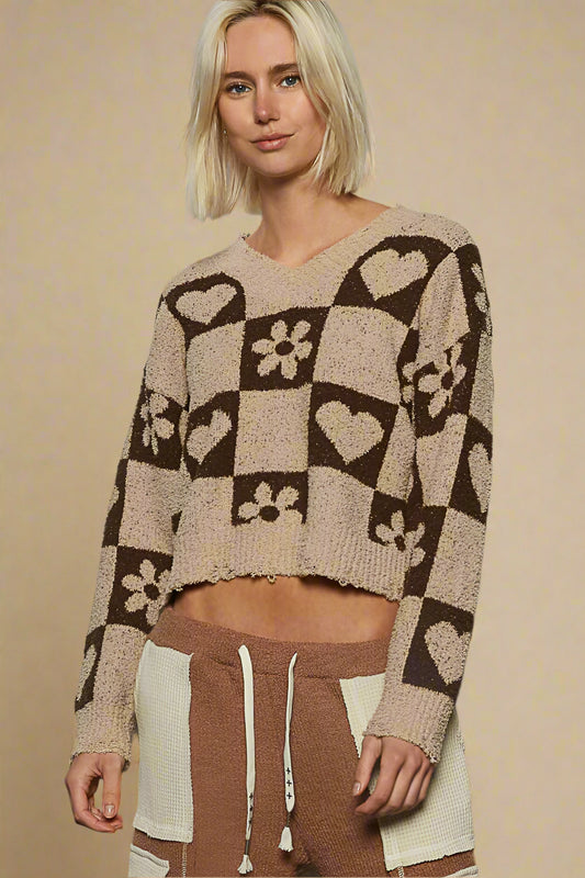 Woman wearing a patterned sweater and pants against a beige background