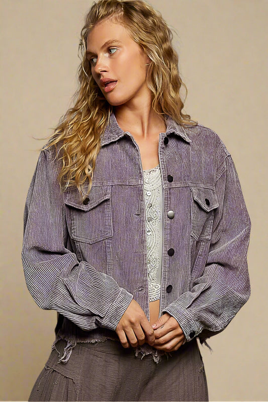 Woman wearing a purple denim jacket against a beige background