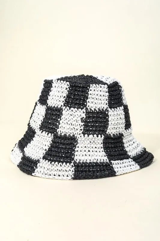 Black and white checkered bucket hat on a beige background