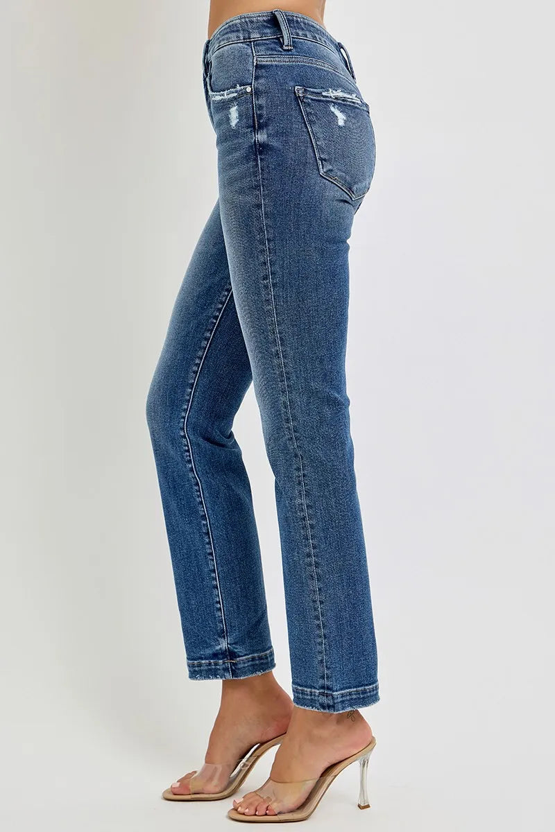 Blue jeans worn by a person on a plain background