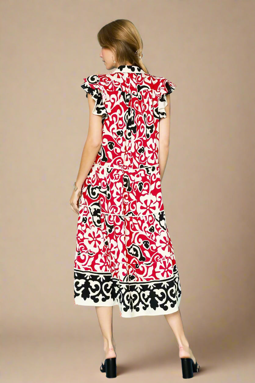 Woman wearing a red, black, and white patterned dress on a light beige background