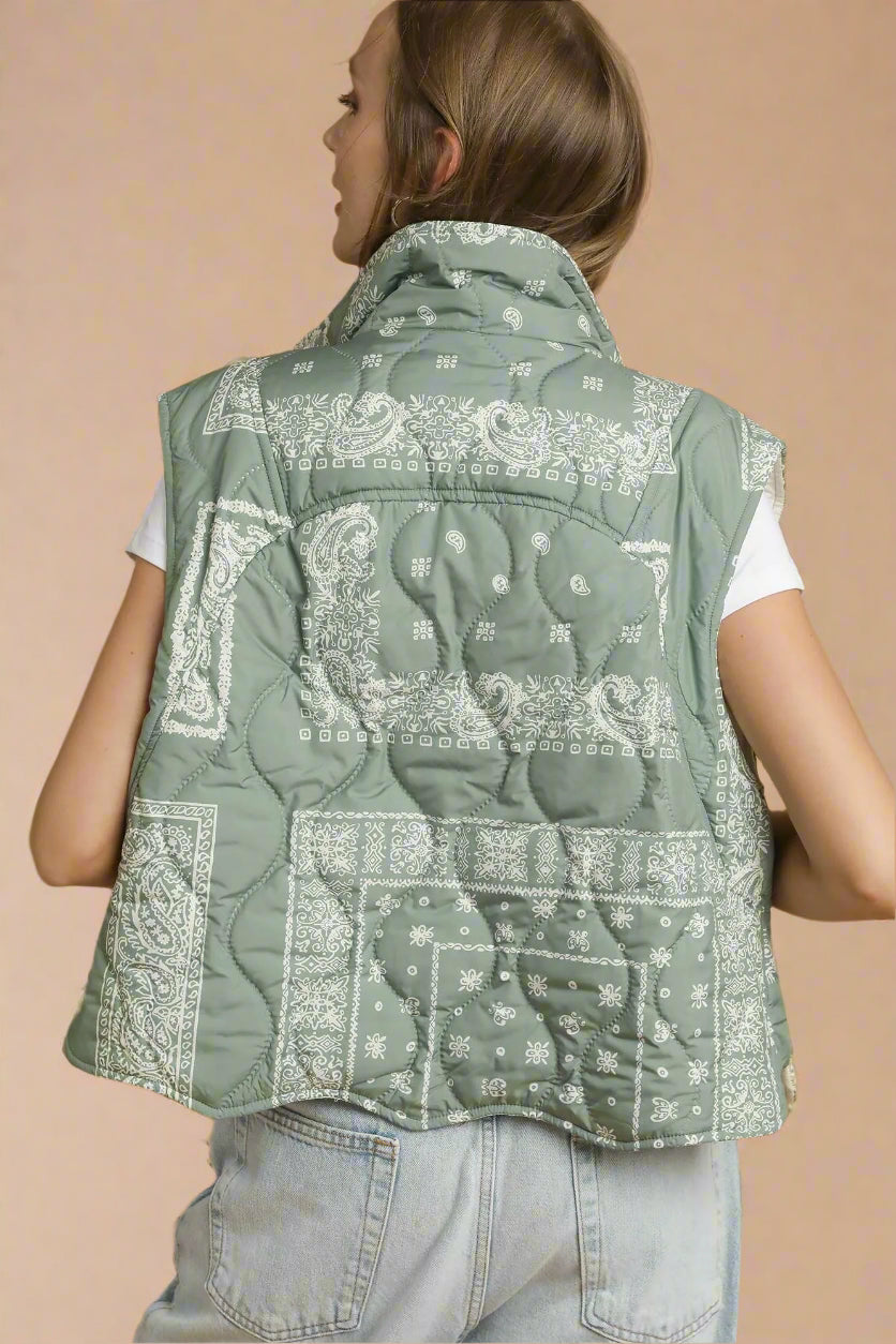 Person wearing a green bandana-patterned vest on a beige background
