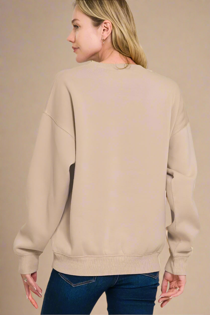 Person wearing a beige sweatshirt on a beige background