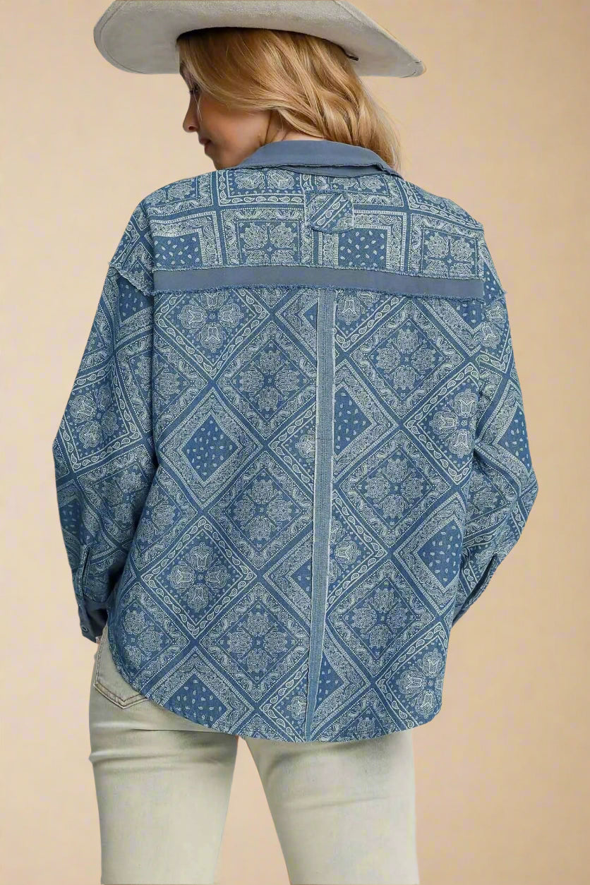 Person wearing a light denim patterned shirt on a plain background