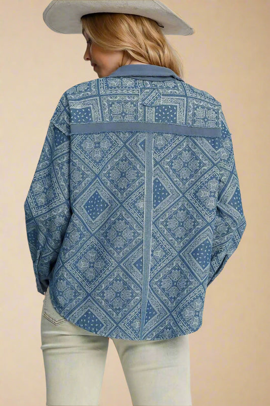 Person wearing a light denim patterned shirt on a plain background