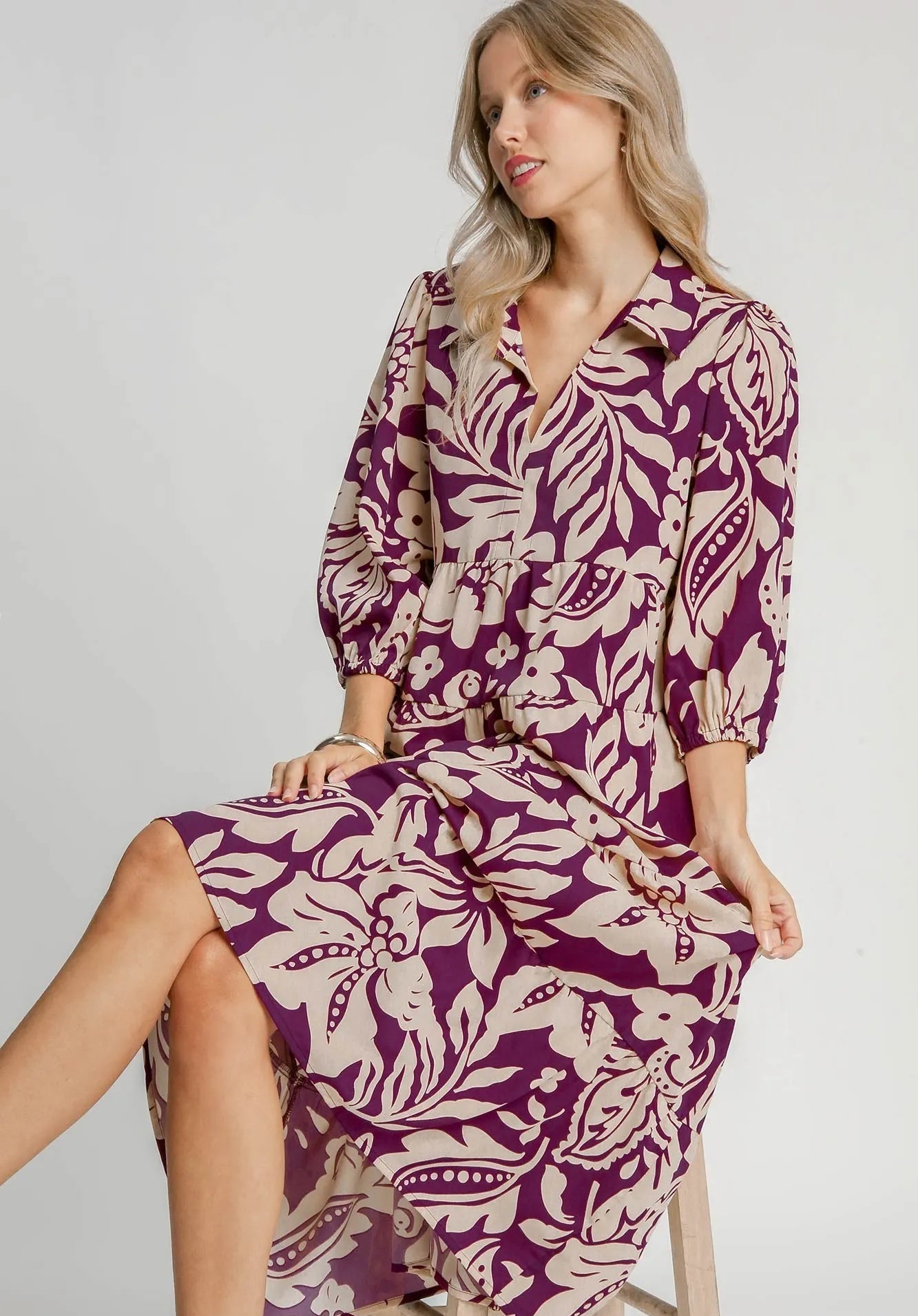 Woman wearing a purple and beige patterned dress on a white background