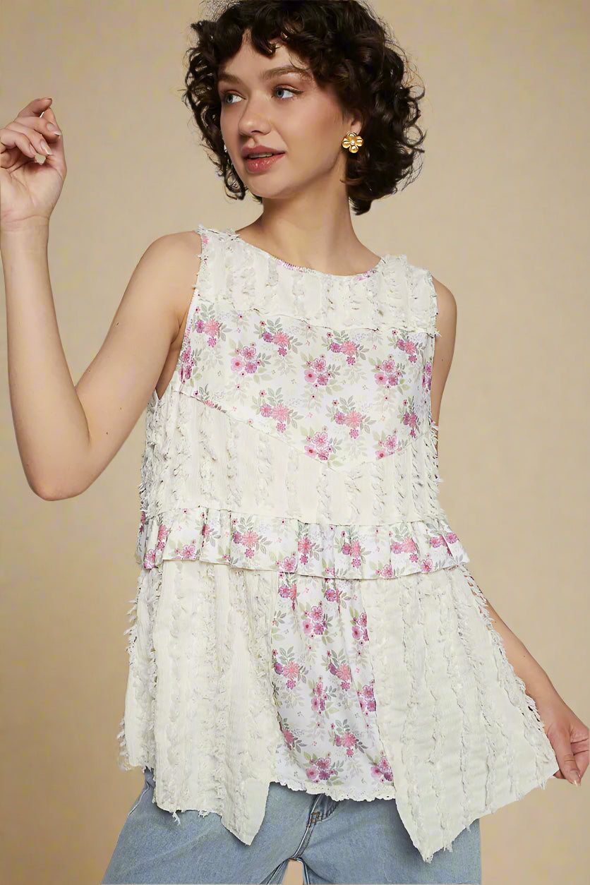 Woman wearing a floral sleeveless top against a plain background