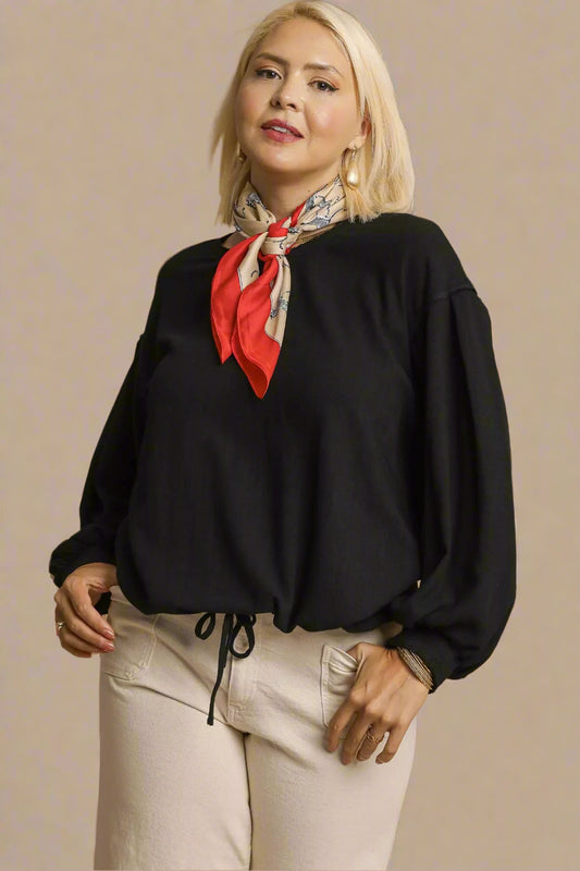 Woman wearing a black blouse with a red scarf on a beige background