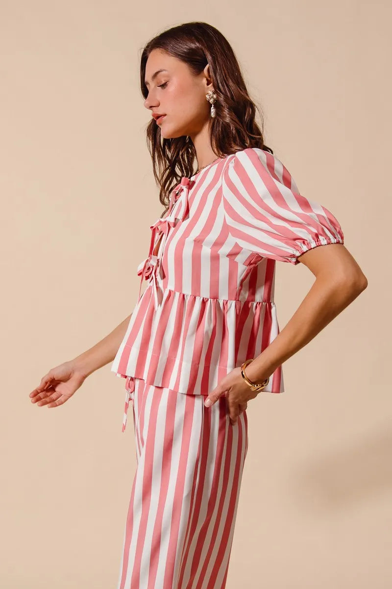 Woman wearing a pink and white striped outfit on a beige background