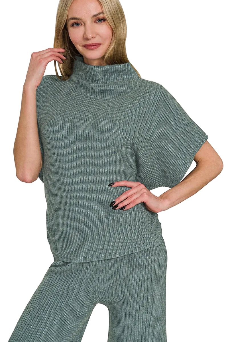 Woman wearing a green knit outfit on a white background