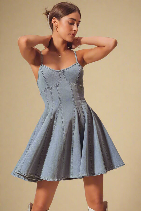 Woman wearing a denim dress against a beige background