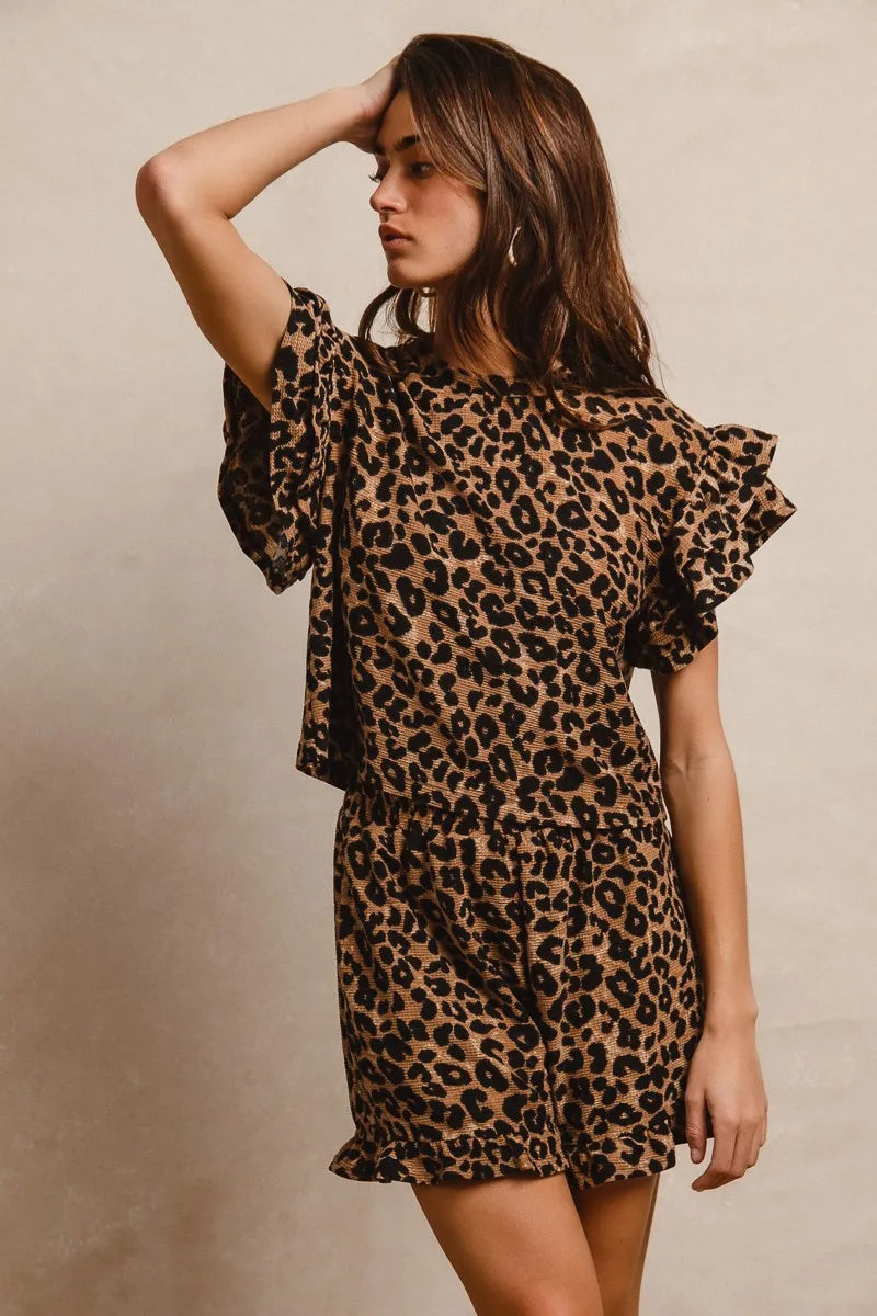 Woman wearing a leopard print dress against a beige background