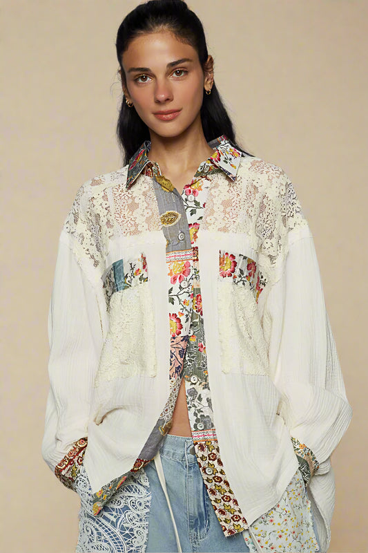 Woman wearing a floral and lace patterned blouse with a gray background