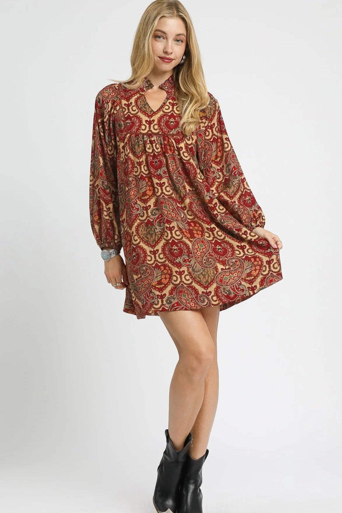 Woman wearing a patterned dress with long sleeves on a white background