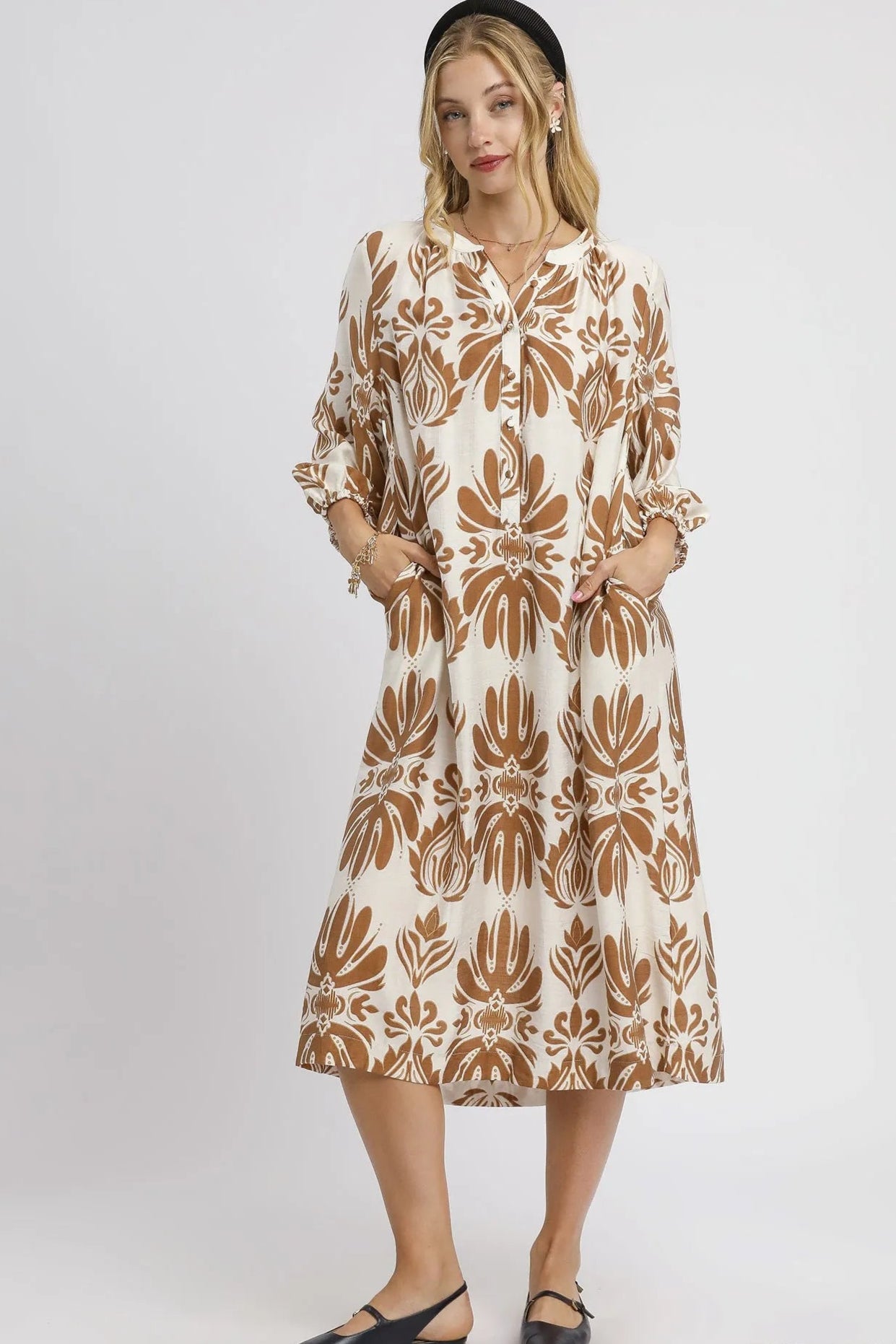 Woman wearing a patterned dress on a white background