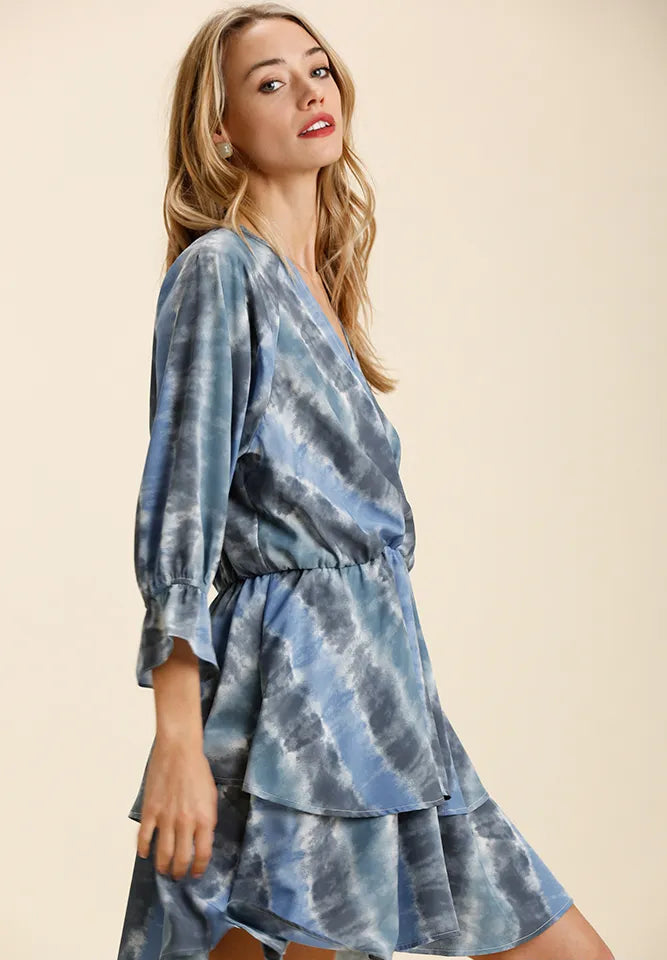 Woman wearing a blue tie-dye dress on a beige background