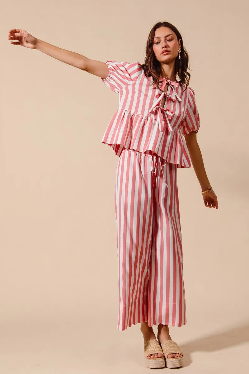 Woman wearing a red and white striped outfit on a beige background