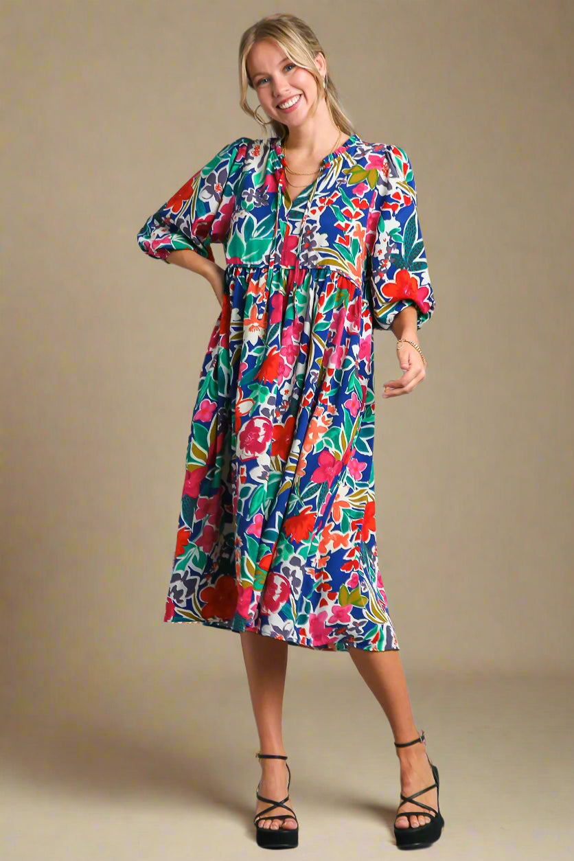 Woman wearing a colorful floral dress on a beige background