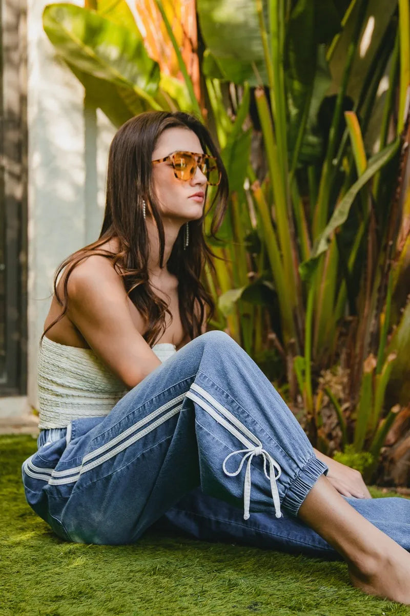 Woman sitting on grass with plants in the background