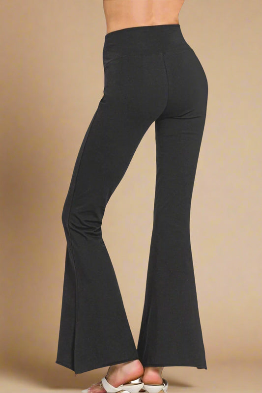 Black bell-bottom pants on a beige background