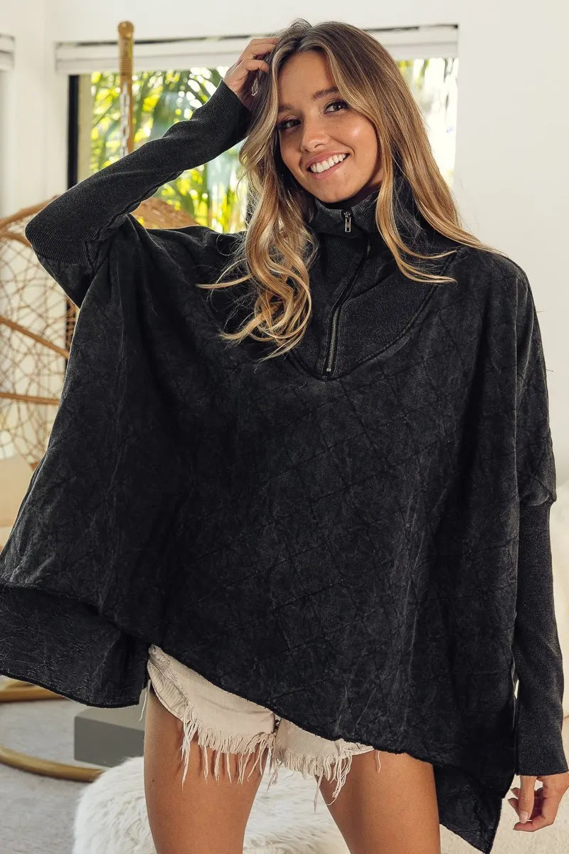 Woman wearing a black poncho with a blurred indoor background