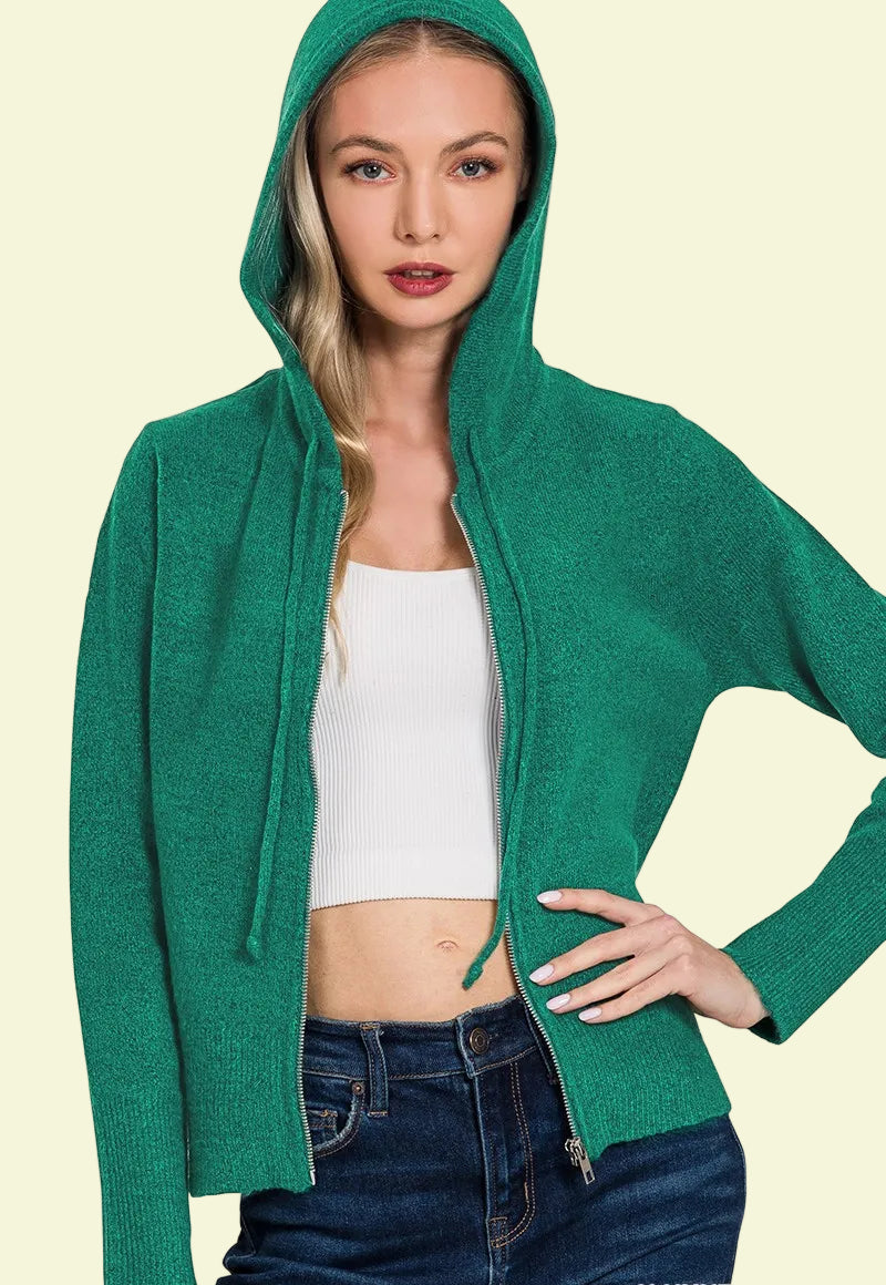 Woman wearing a green hoodie with a plain background