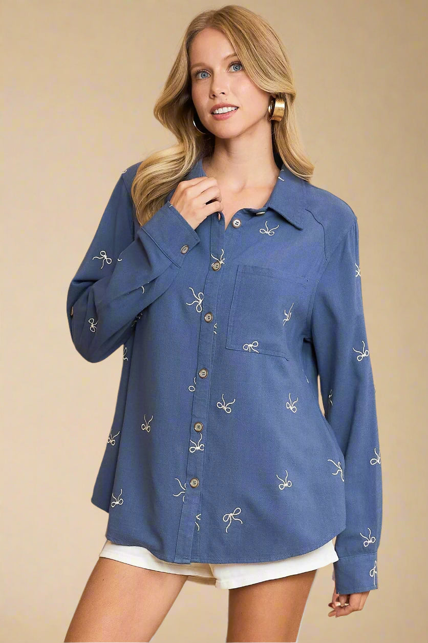 Woman wearing a blue shirt with white patterns on a beige background