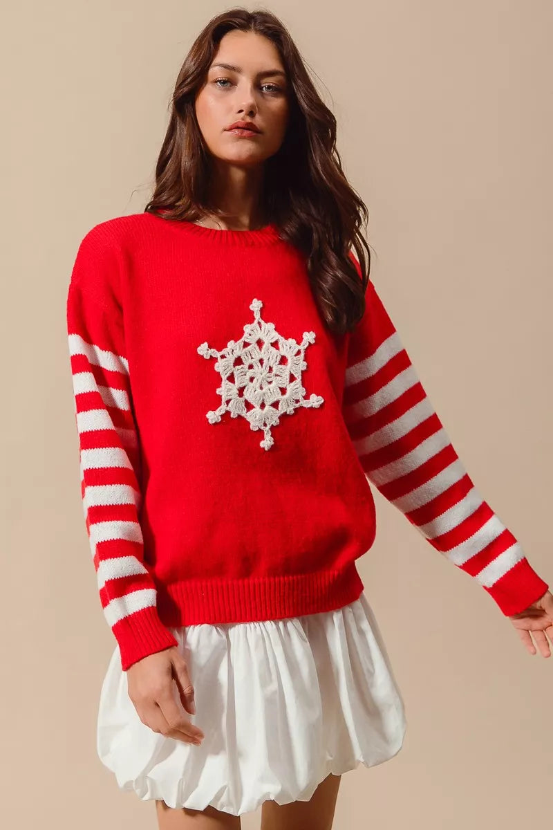Woman wearing a red sweater with a white snowflake design on a beige background