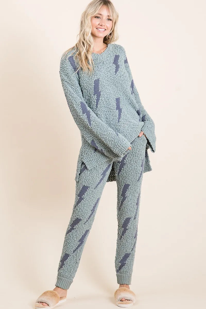 Woman wearing a matching blue sweater and pants set on a beige background