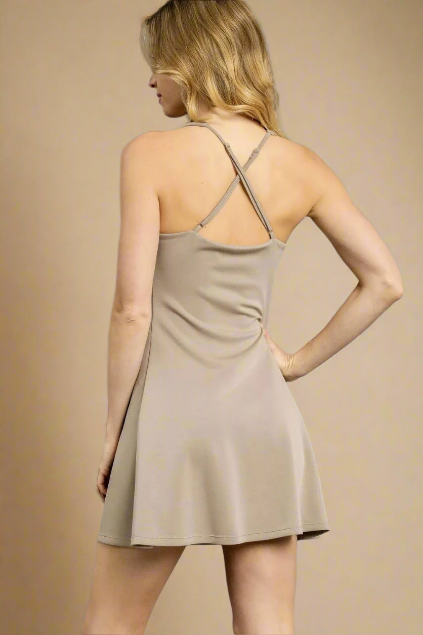 Woman wearing a beige dress against a gray background