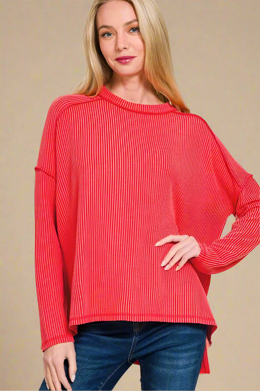 Woman wearing a red sweater with a plain background