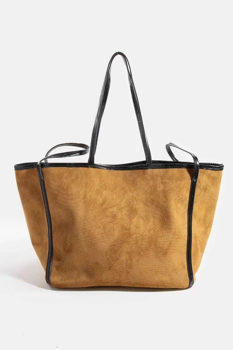 Tan tote bag with black handles and trim on a white background