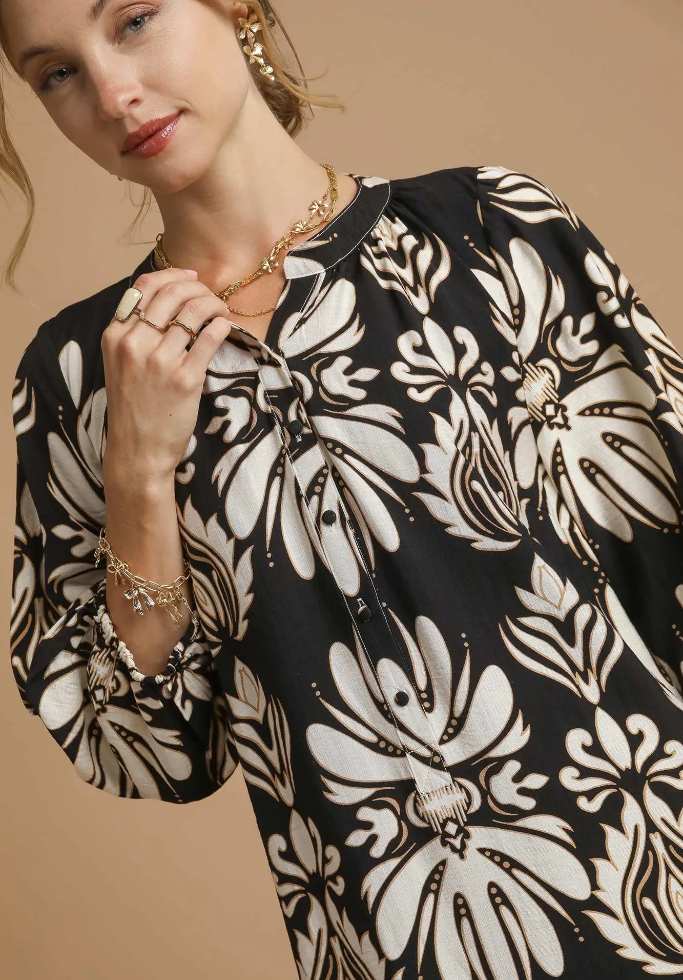 Woman wearing a black and white floral dress with a beige background