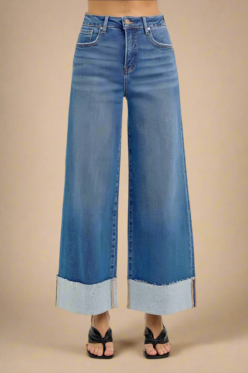 Wide-leg blue jeans on a beige background