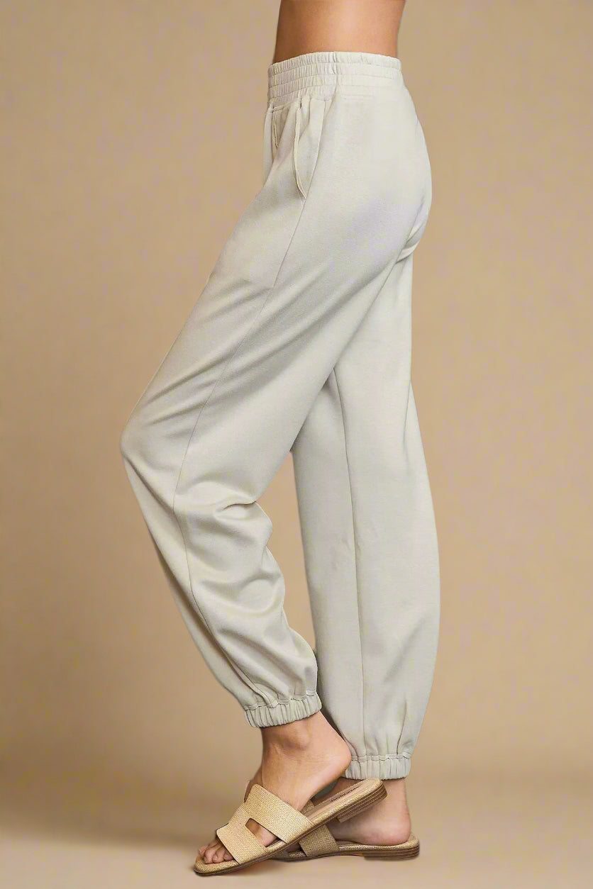 Light gray pants worn by a person on a dark gray background