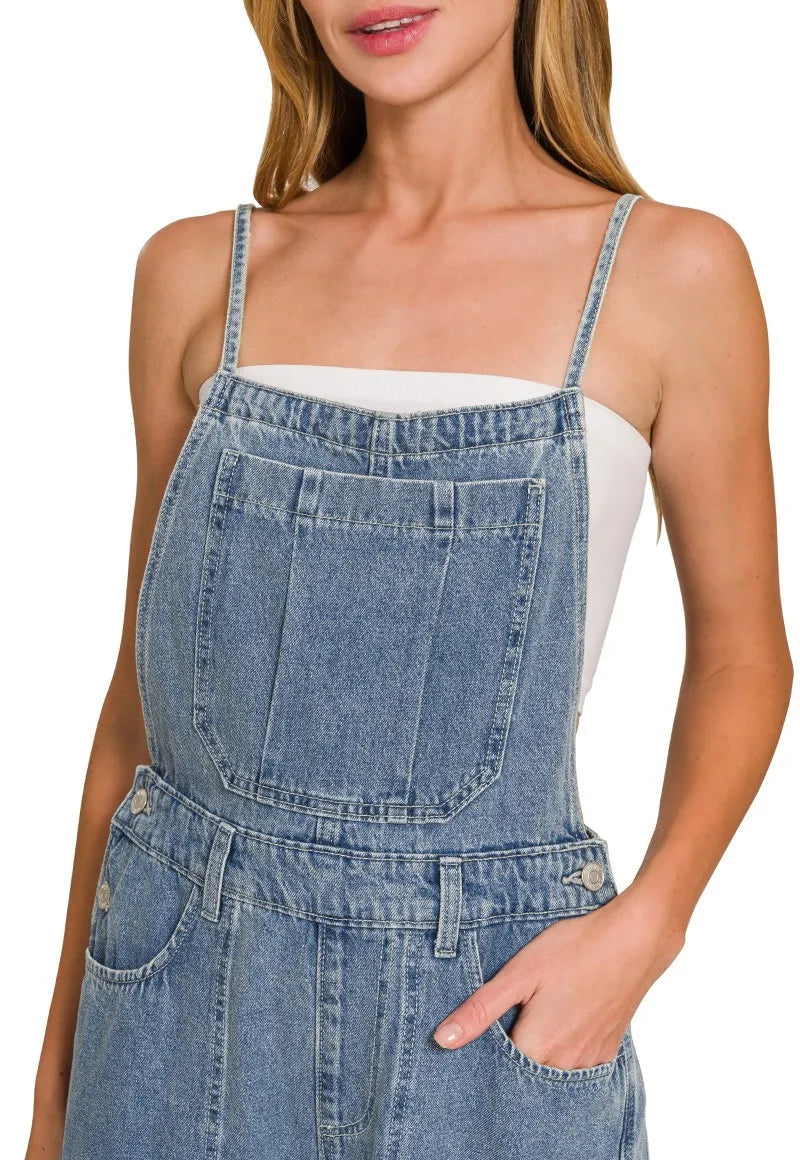 Denim overalls worn by a model on a white background