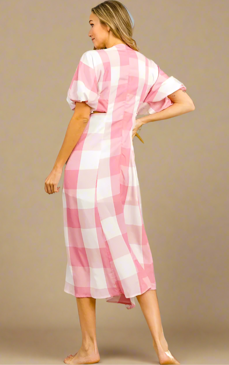 Woman wearing a pink and white striped dress on a beige background.