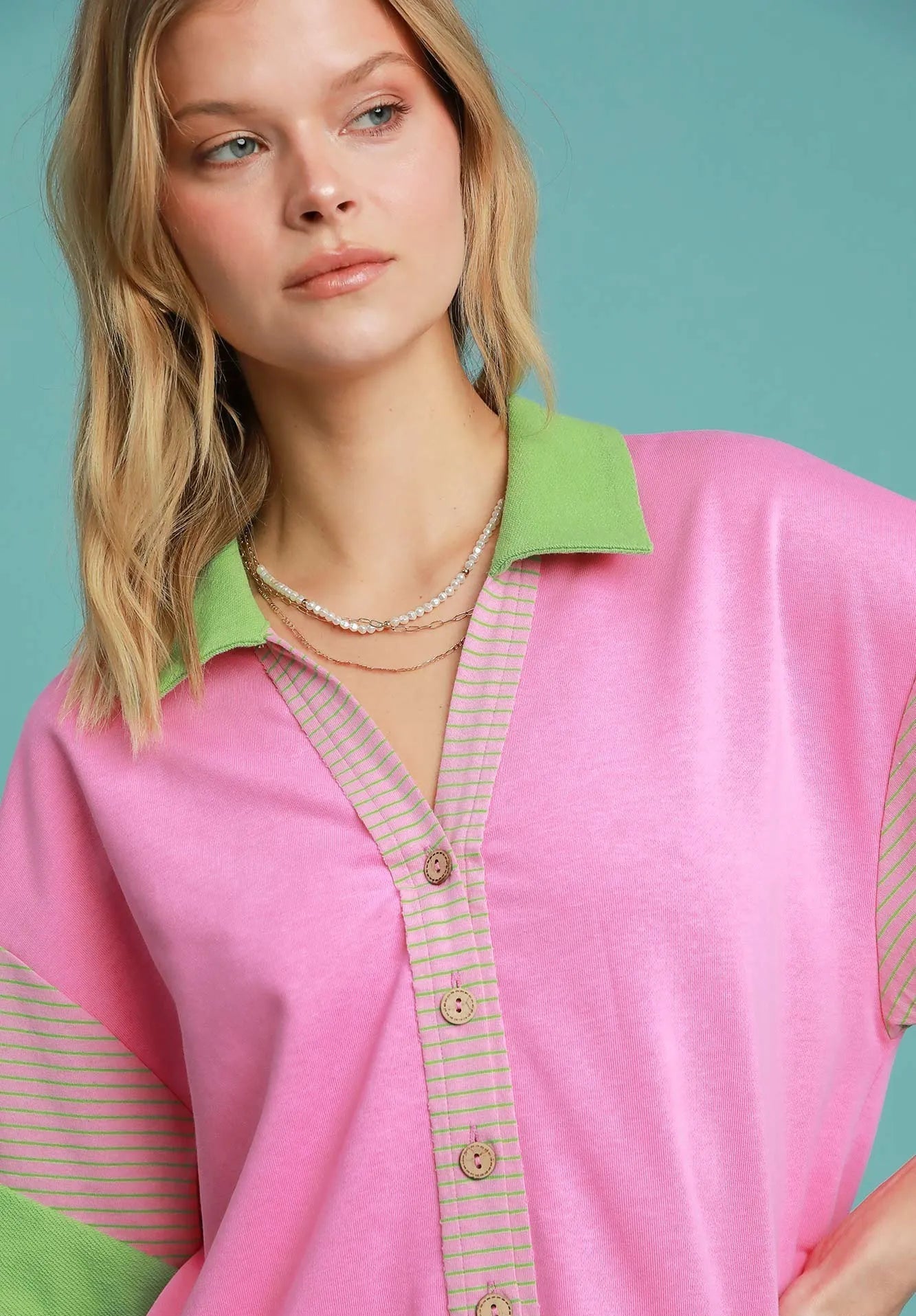 Woman wearing a pink and green outfit with a blue background