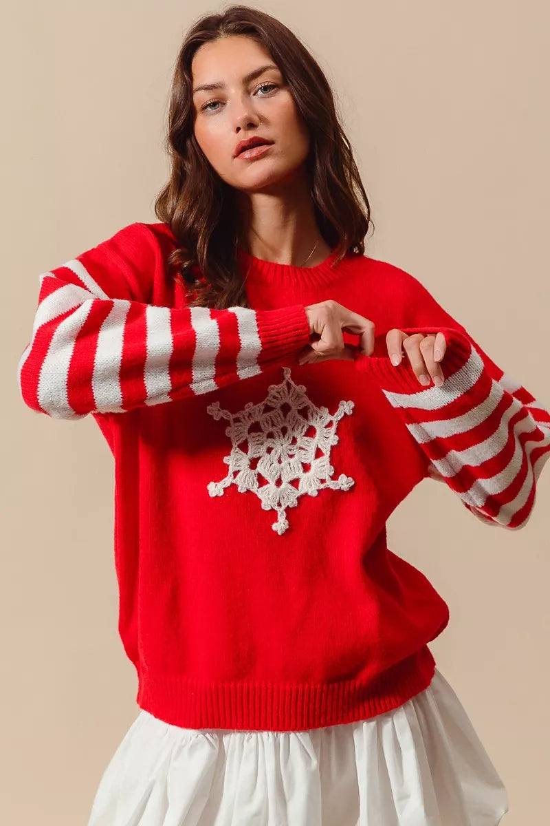 Woman wearing a red sweater with white snowflake design on a beige background