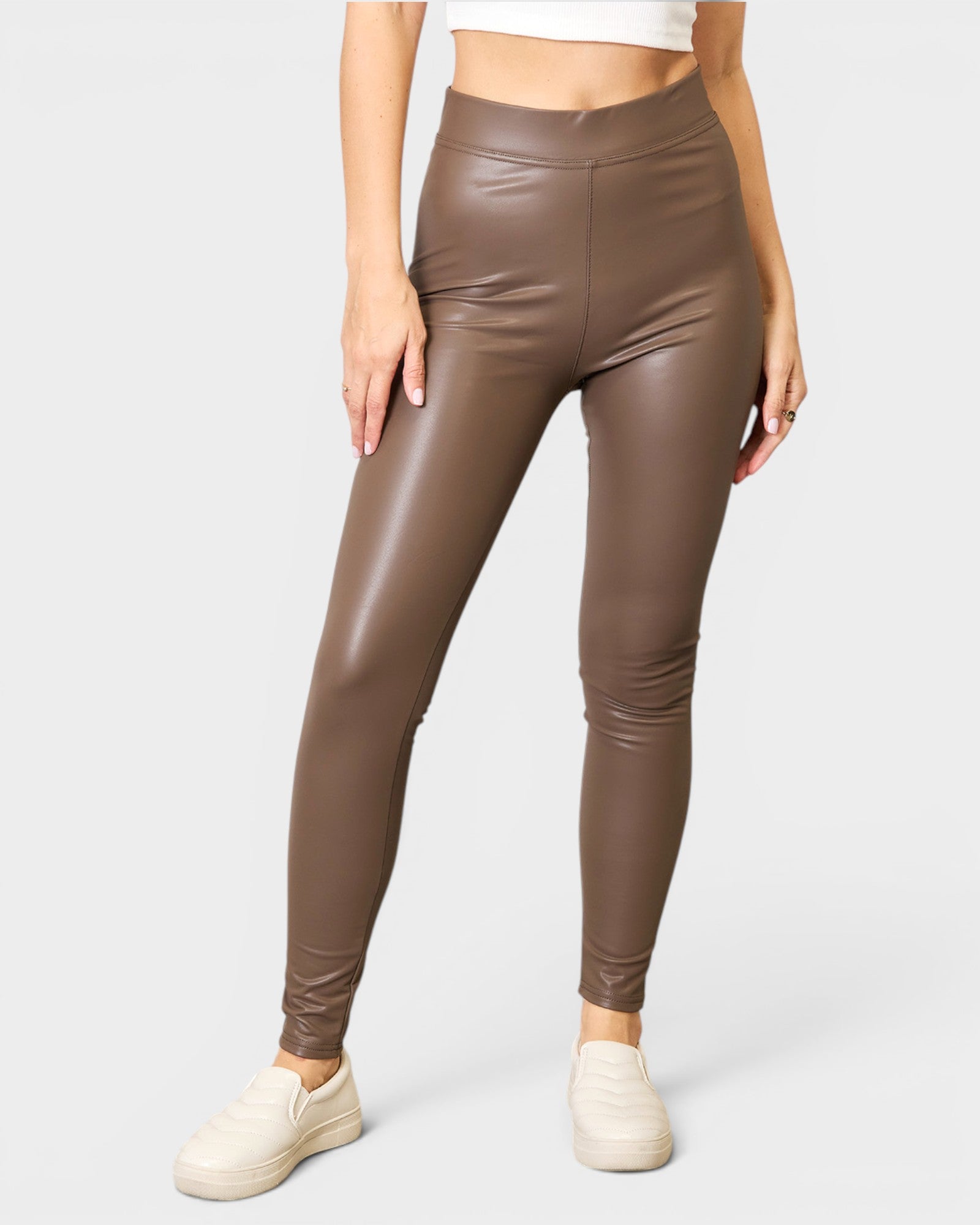 Brown leather leggings worn by a person on a white background