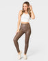 Woman wearing brown leggings and a white top on a white background