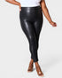 Person wearing black leather leggings on a white background