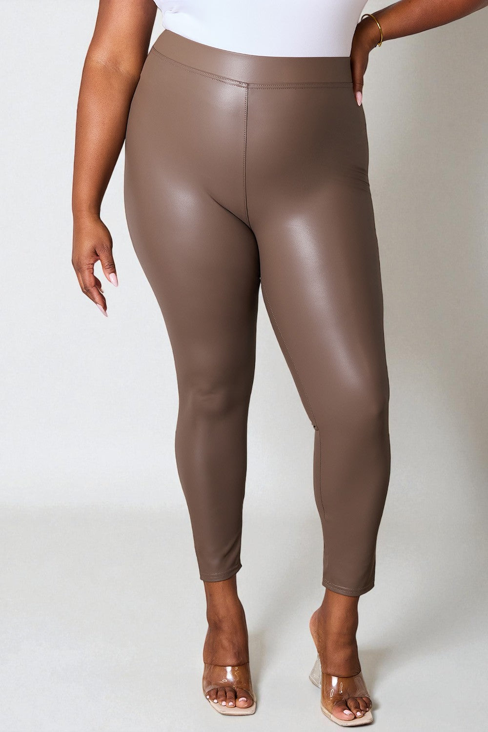 Brown leather leggings worn by a person on a white background