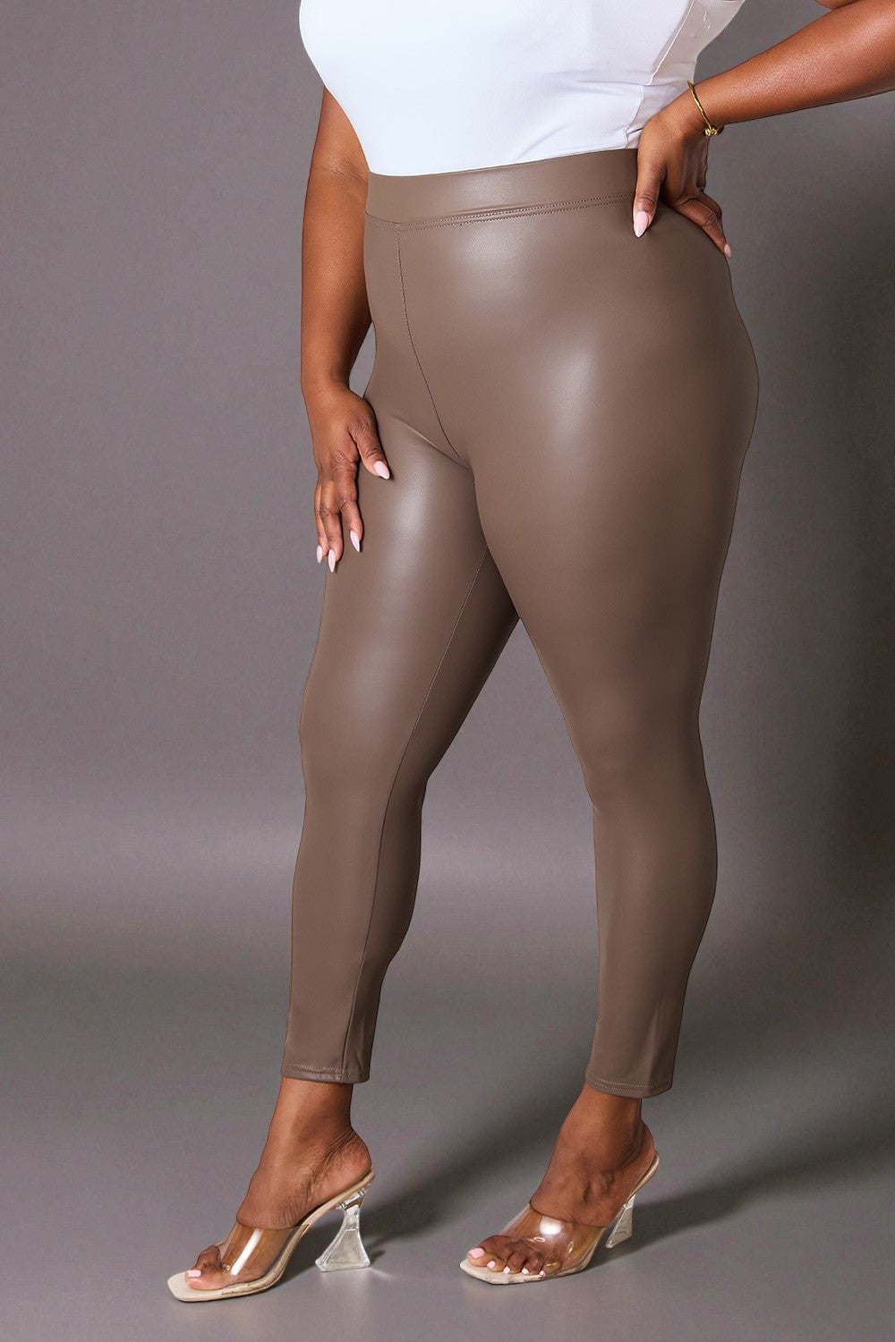 Person wearing brown leggings against a gray background