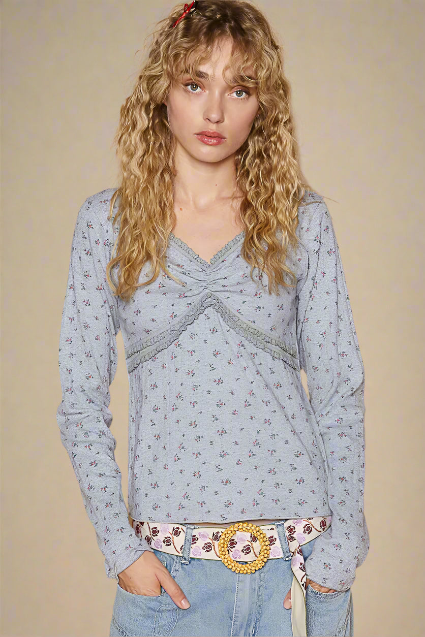 Woman wearing a light blue floral blouse with a beige background