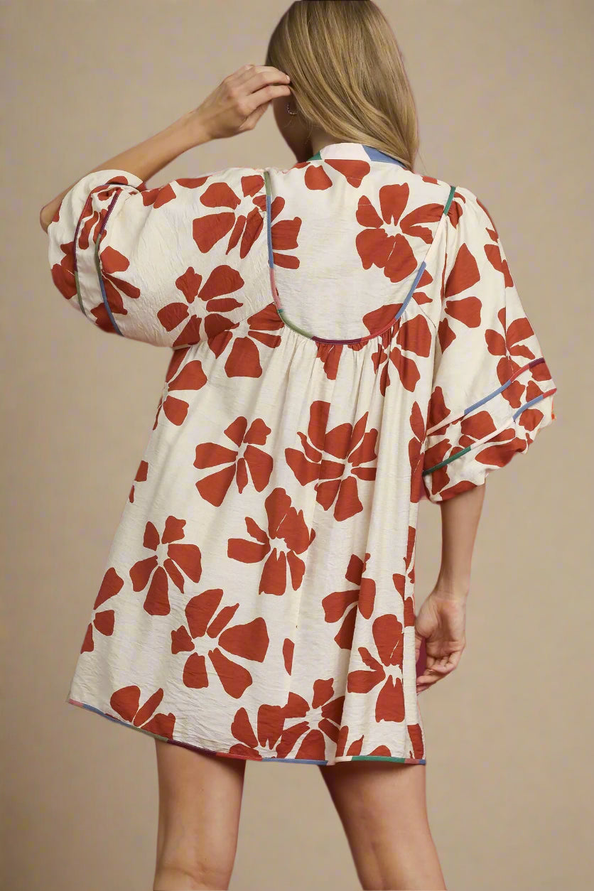 Woman wearing a floral dress with red flowers on a beige background